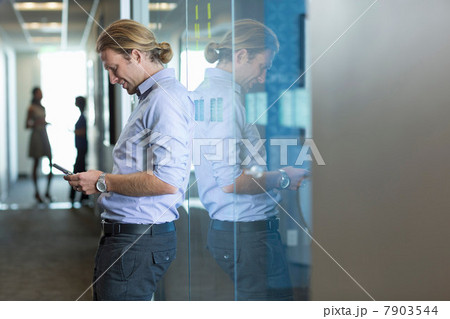 Businessman using cell phone in office 7903544