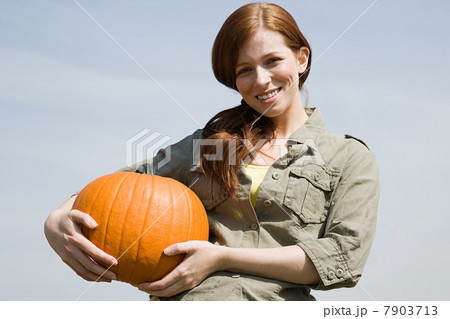 Young woman holding a pumpkin 7903713