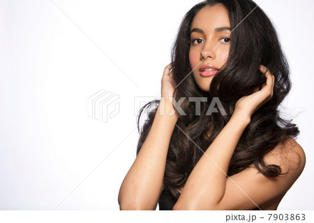 Young woman with hands in hair against white background 7903863