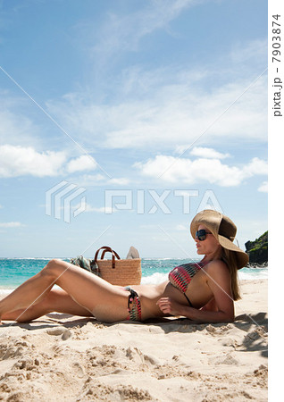 Woman lying on sandy beach, Mustique, Grenadine Islands Woman lying on sandy beach, Mustique, Grenadine Islands 7903874