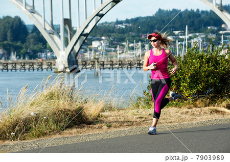 Young woman running on path near the sea 7903989