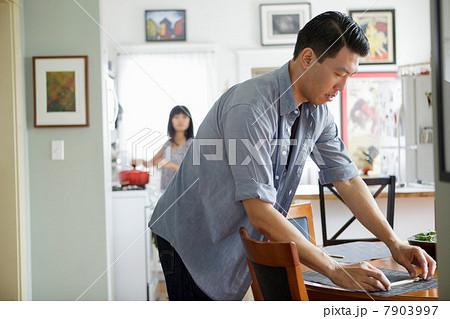 Man setting table in dining room Man setting table in dining room 7903997