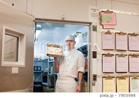 Male chef in walk in freezer in commercial kitchen 7903998