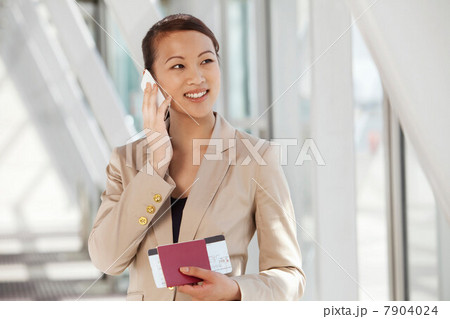 Businesswoman on cell phone with airline ticket and passport Businesswoman on cell phone with airline ticket and passport 7904024