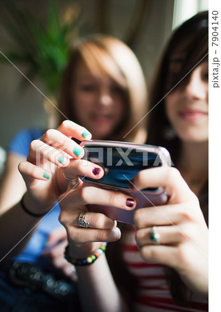 Two teenage girls using smartphone 7904140