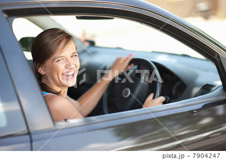 Teenage girl in braces driving car Teenage girl in braces driving car 7904247