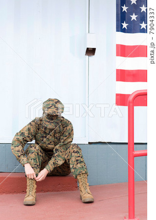Servicewoman in camouflage by US flag 7904337
