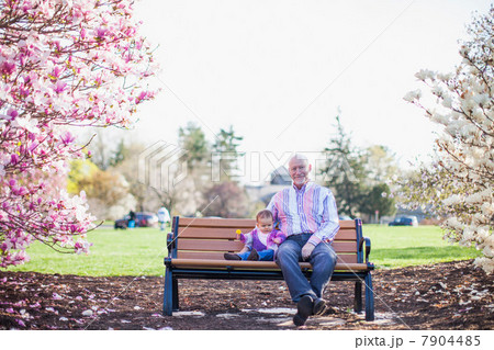 Grandfather and granddaughter sitting on park bench Grandfather and granddaughter sitting on park bench 7904485
