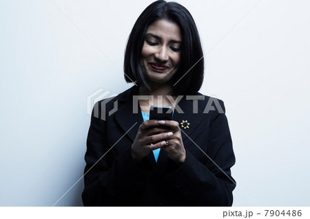 Studio portrait of businesswoman looking at cellphone Studio portrait of businesswoman looking at cellphone 7904486
