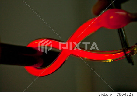 Close up of red hot glass being bent in glass factory 7904525