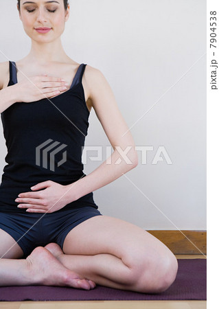 Women breathing deeply, touching chest and abdomen 7904538