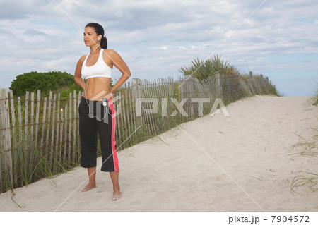 Mid adult woman in sportswear on beach 7904572
