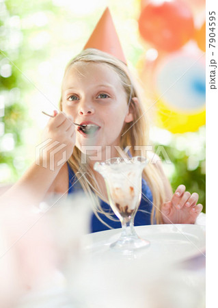 Girl having ice cream sundae at party 7904595