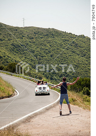 Convertible car driving past hitchhiker Convertible car driving past hitchhiker 7904749