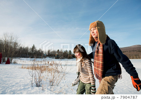Brother and sister walking in snow 7904787