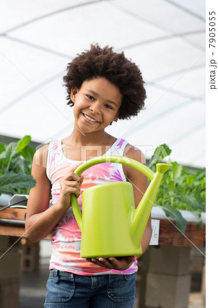 Girl holding green watering can 7905055