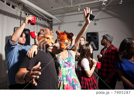 People wearing lion and tiger masks dancing at party People wearing lion and tiger masks dancing at party 7905287