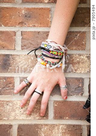 Woman's hand with bracelets by brick wall Woman's hand with bracelets by brick wall 7905494