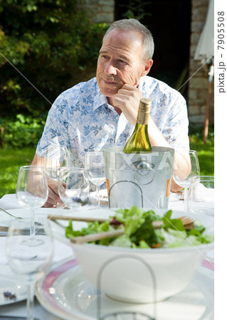 Senior man having lunch with wine outdoors Senior man having lunch with wine outdoors 7905508