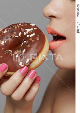 Young adult woman eating doughnut Young adult woman eating doughnut 7905620