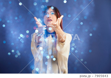 Portrait of young woman catching glitter 7905643