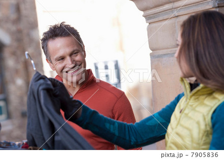 Mature man and young woman clothes shopping, smiling 7905836
