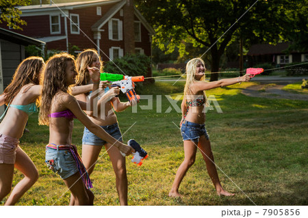Girls having water fight with water pistols 7905856