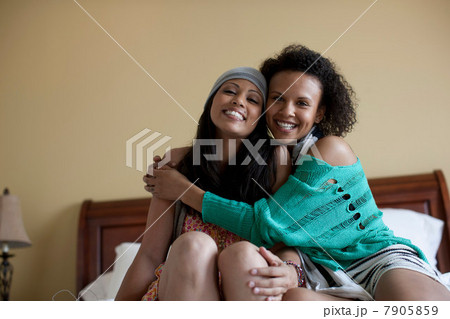 Young women embracing on bed, portrait 7905859