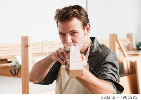 Carpenter checking angle of wood in workshop Carpenter checking angle of wood in workshop 7905885