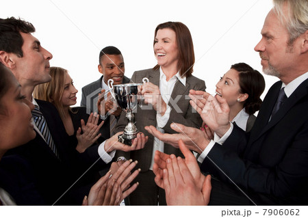Businesswoman receiving trophy, colleagues clapping 7906062