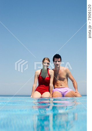 Young couple by swimming pool, portrait 7906120