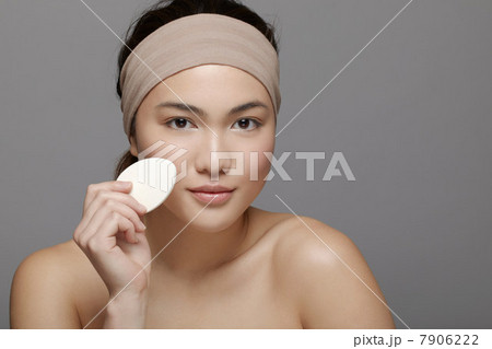 Young woman using make up sponge 7906222