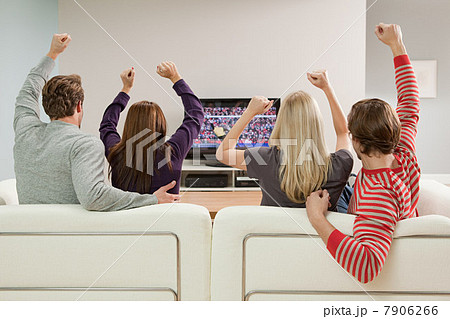 Four friends watching football on television Four friends watching football on television 7906266