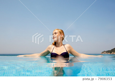 Young woman in infinity pool, looking away Young woman in infinity pool, looking away 7906353