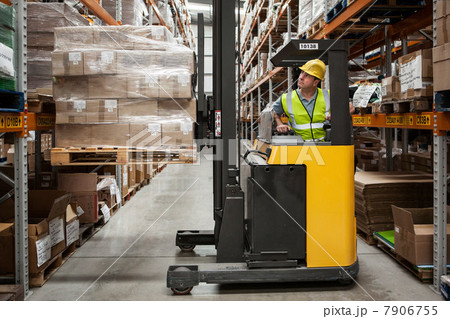 Man transporting stock in distribution warehouse 7906755