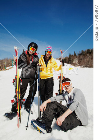 Three friends wearing skiwear with skis 7906977