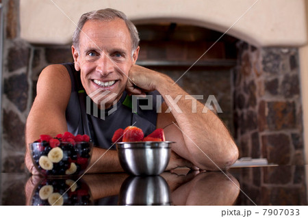 Older man having fruit in kitchen 7907033