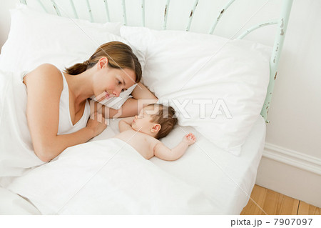 Mother watching baby girl sleep 7907097