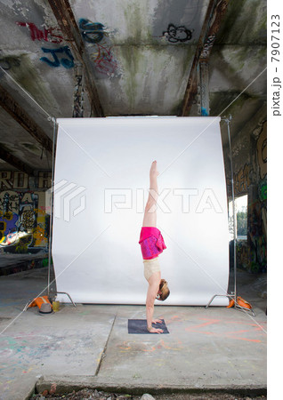 Female acrobat practicing handstand in old industrial interior 7907123