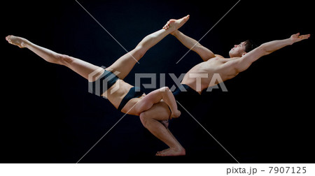 Mid adult dancers performing together in front of black background 7907125