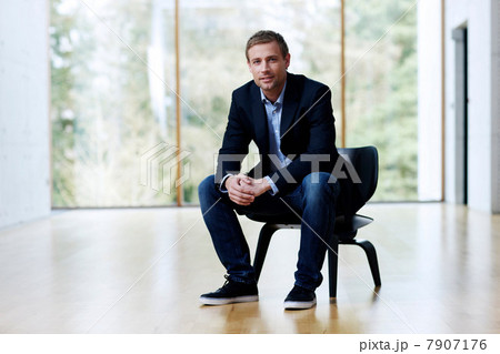 Businessman sitting on black chair, portrait 7907176