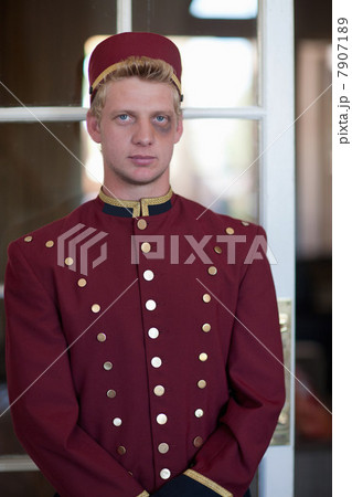 Bellhop with black eye in hotel lobby 7907189