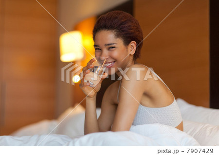 Young woman drinking a glass of water in bed 7907429
