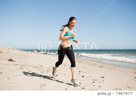 Woman jogging on beach 7907677