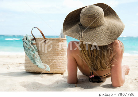 Woman lying on sandy beach, Mustique, Grenadine Islands Woman lying on sandy beach, Mustique, Grenadine Islands 7907736