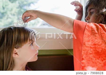 One girl putting tiara on another girl One girl putting tiara on another girl 7908028