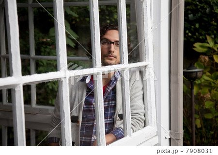 Man looking out window 7908031