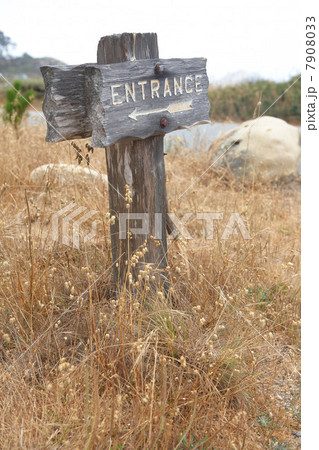 Wooden entrance sign in grass 7908033