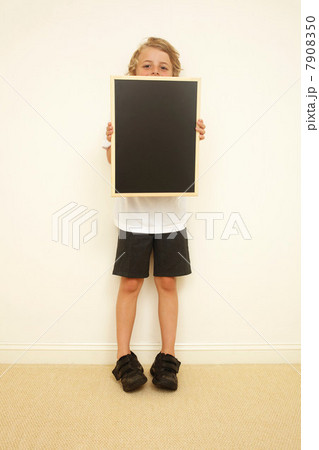 Schoolboy holding blank blackboard 7908350