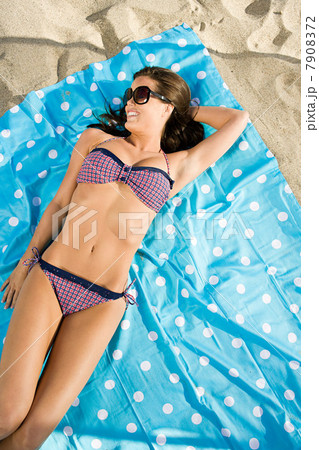 Young woman sunbathing at the beach 7908372